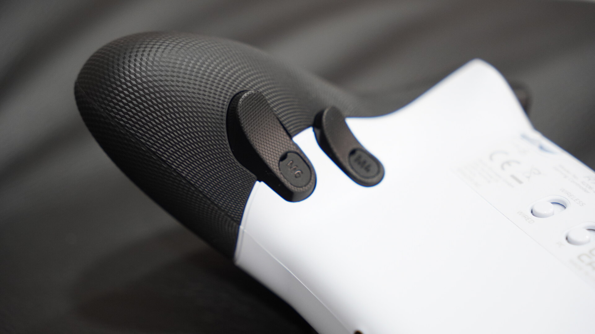 Close-up da pega texturizada do comando Razer Raiju V3 Pro com bot&otilde;es traseiros adicionais vis&iacute;veis.